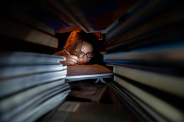 Stresli bir kadın final sınavları için kütüphanede çalışıyor..