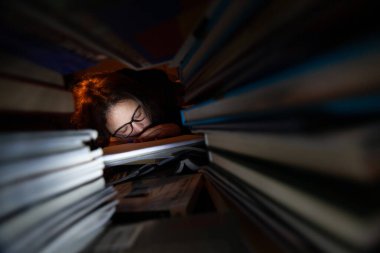 Sınavları sırasında kütüphanede uyuyan yorgun bir kadın..