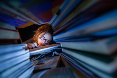 Geceleri kütüphanede ders çalışan yorgun bir kadının fotoğrafını çek.