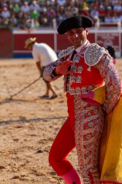 close up of a smiling bullfighter dressed with typical hat greeting the public after the end of a bullfight clipart