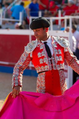 Boğa güreşinden hemen önce tipik şapka takan bir İspanyol boğa güreşçisi peleriniyle pratik yapıyor.