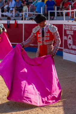 Boğa güreşinden hemen önce tipik şapka takan bir İspanyol boğa güreşçisi peleriniyle pratik yapıyor.
