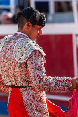 Boğa güreşinden hemen önce tipik şapka takan bir İspanyol boğa güreşçisi peleriniyle pratik yapıyor.