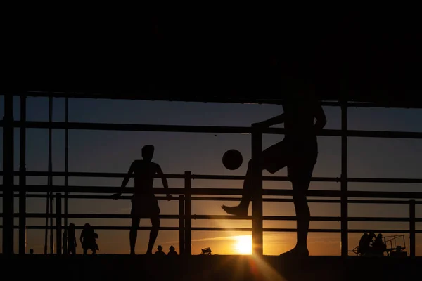 Silueta Dos Jóvenes Jugando Fútbol Una Pasarela Portuaria Una Playa —  Fotos de Stock