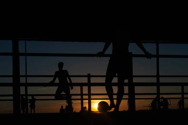 Silueta Dos Jóvenes Jugando Fútbol Una Pasarela Portuaria Una Playa — Foto de Stock