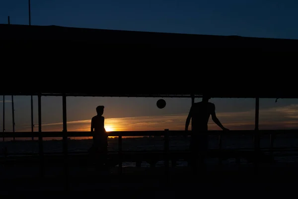 Silueta Dos Jóvenes Jugando Fútbol Una Pasarela Portuaria Una Playa —  Fotos de Stock