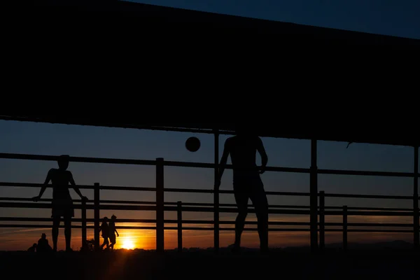 Silhouette Zweier Junger Leute Beim Fußballspielen Auf Einem Hafensteg Einem — Stockfoto