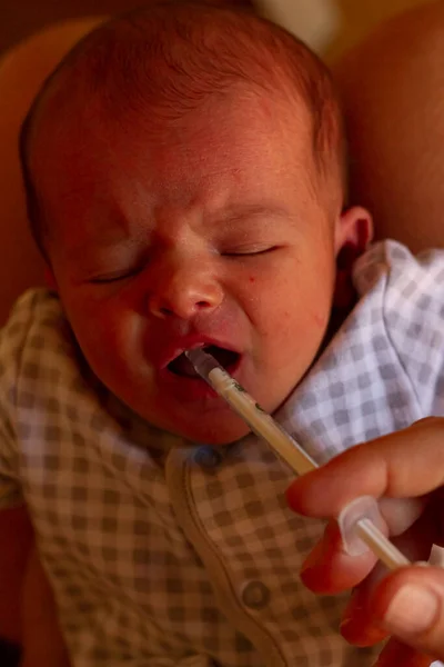 Adorable Newborn Baby Crying Taking Vitamin ロイヤリティフリーのストック画像