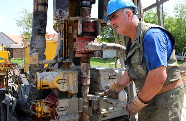 Perfuração do trabalhador do óleo para o óleo no equipamento — Fotografia de Stock