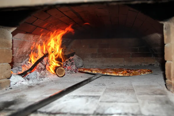 Выпечка пиццы в дровяной печи — стоковое фото