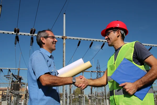 Ingenjör och arbetstagare vid elektriska transformatorstation — Stockfoto