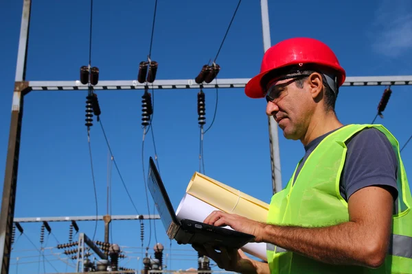 Ingeniero eléctrico con ordenador portátil y planos — Foto de Stock