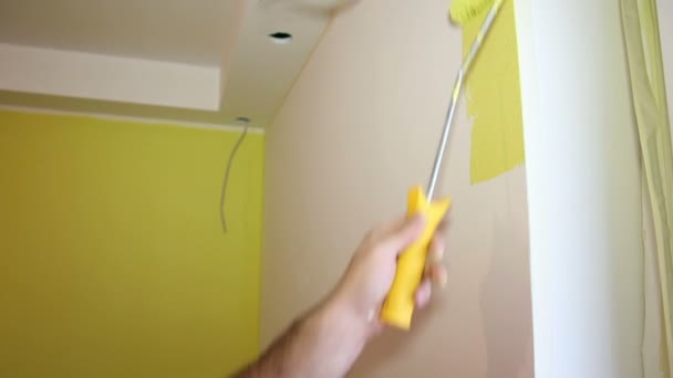 La mano del hombre pintando una pared amarilla — Vídeo de stock