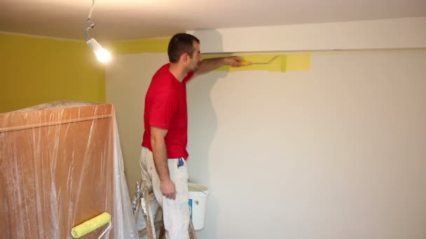 Hombre en escalera pintura pared — Vídeo de stock