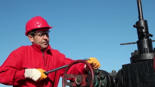 Техник нефтяной буровой установки за работой — стоковое видео