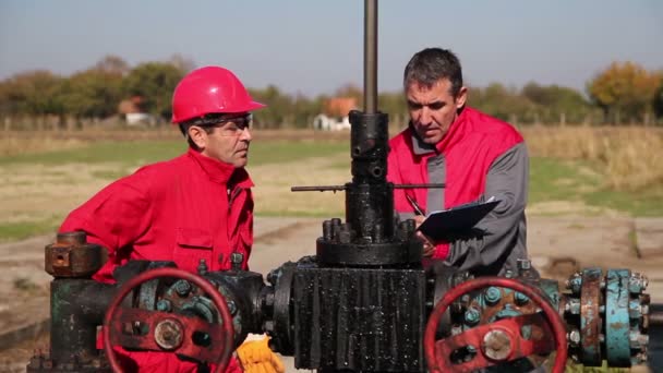 Lavoratori petroliferi a pozzo pompa Jack sito — Video Stock