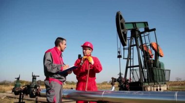 petrol kuyusu önünde iki işçi