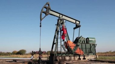 Petrol işçisi petrol platformunda vanayı çeviriyor.