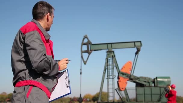 Engenheiro dando ordens para o trabalhador de petróleo — Vídeo de Stock