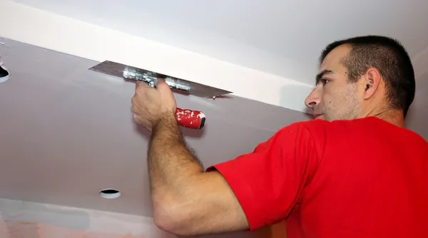 Hombre aplicando yeso en una pared seca —  Fotos de Stock