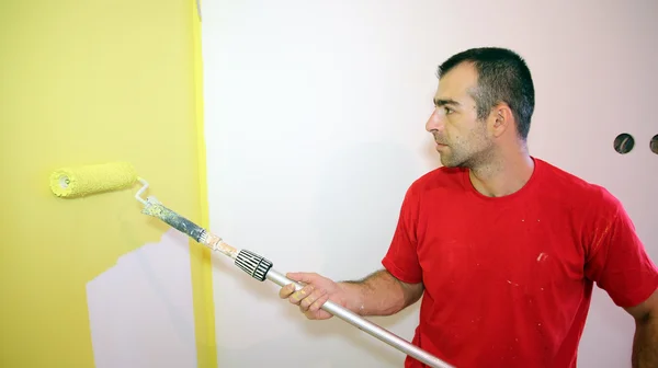 Hombre joven pintando apartamento — Foto de Stock