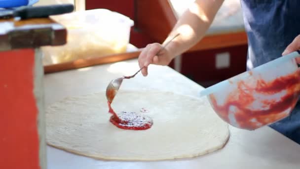 Espalhando molho de tomate em uma base de pizza — Vídeo de Stock