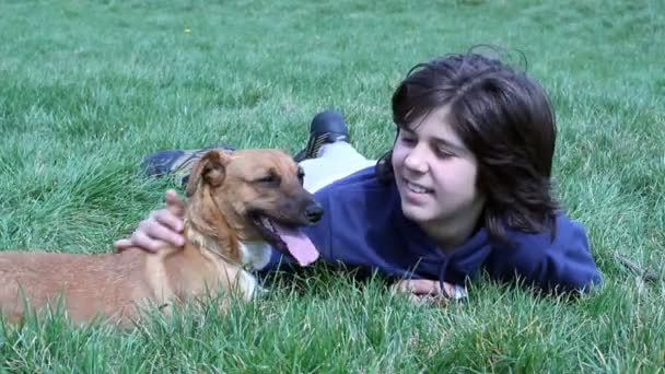 Garçon couché dans l'herbe avec son chien — Video