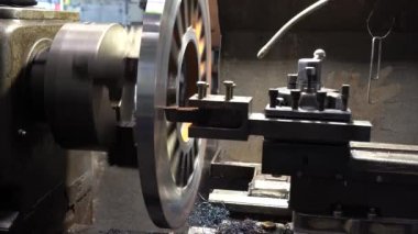 Torna Makinesi bir tren fabrikasında metal parçası işliyor. Metal endüstrisindeki Torna Makinesi Kesme Aracı ile Çelik Parçalarını Kesme İşlemi. 