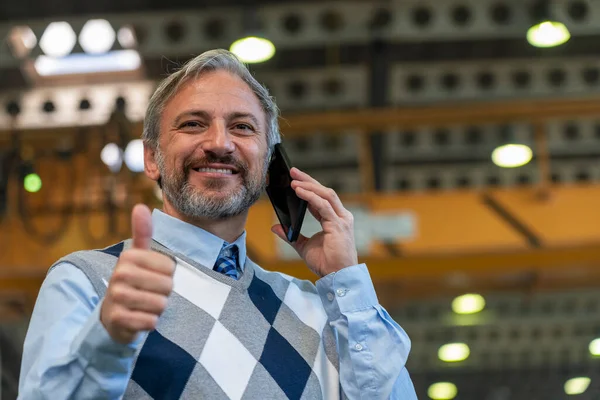 Gerente Sonriente Mirando Cámara Hablando Teléfono Inteligente Dando Pulgar Hacia Imagen de archivo