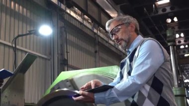 Tren fabrikasındaki raylı tekerlek imalatı zum yaptı. Torna makinesinin yanında Afrikalı Amerikalı CNC operatörü Kafkas Kalite Kontrol Müfettişi ile konuşuyor. Dijital Tablet Kullanıcı Yöneticisi. 