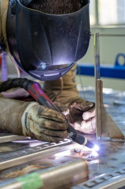 Worker With Welding Helmet And Protective Workwear Welding Train Construction. Portrait Of Welder With Torch At The Train Factory.