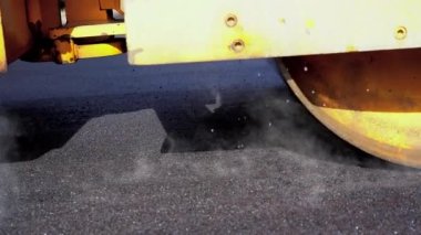 Ağır çekimde Road Roller Paving Caddesi. Steamroller Yeni Bir Yol 'da Sıcak Asfalt Sıkıştırıyor. Yol İnşaat İşleri. Fışkırtan ve Taze Bitumen serpiştiren.