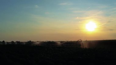 Tarım Sulama Sistemi Bereketli Çiftlik Arazisindeki Ekinleri Sulama. Tarım Alanının Üzerinde Güzel Gün Batımı. Sulama Sistemi Tarım Arazisindeki Ekinlere Su Söndürüyor.