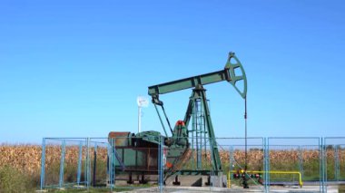 Tarım arazisinde petrol endüstrisi Jack Petrol Kuyusu Pompaladı. Fosil Yakıt Enerjisi. Petrol endüstrisi ekipmanları. Petrol Sahası Mavi Gökyüzüne Karşı Pompa.