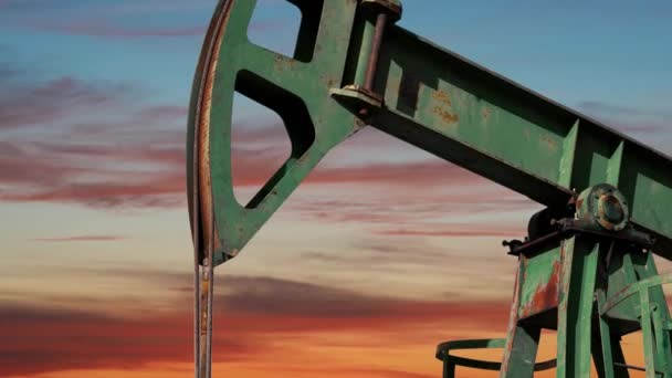 オイルポンプジャックは日没時に原油を抽出します 化石燃料エネルギー 石油産業機器 作業油リグの上に移動雲と美しいオレンジの空 — ストック動画