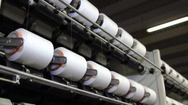 Tekstil endüstrisinde iplik üretimi. İplik, kumaş, dokuma ve dikiş üretiminde kullanıma uygun uzun iplikler üretmek için pamuk veya diğer maddelerin iplikçikleri tarafından üretilir.