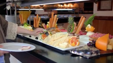 Choosing Breakfast At Restaurant Buffet. Unrecognizable Person Serving Food In Plate. Side View Of Woman Choosing Food At Restaurant Buffet. Self Service Catering Buffet.
