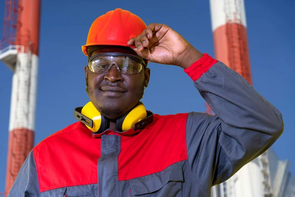 Αφροαμερικάνος Εργάτης Προστατευτικά Ενδύματα Που Στέκεται Μπροστά Από Βιομηχανικές Καμινάδες — Φωτογραφία Αρχείου