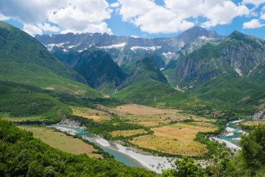 Arnavutluk 'ta 8 Haziran 2021' de karlı zirvelerin zemininde bir dağ nehri bulunan vadi