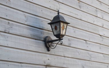 Ahşap bir duvarda klasik sokak lambası