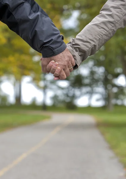 Pareja madura cogida de la mano — Foto de Stock