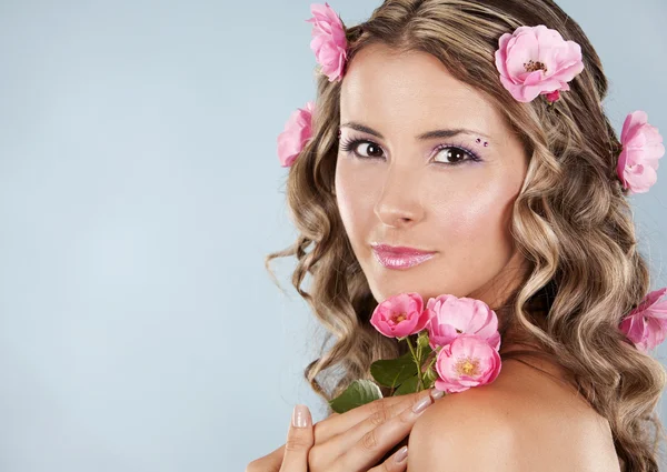 Krásná tvář s růžovými růžemi — Stock fotografie
