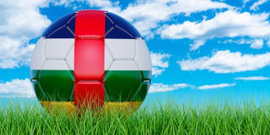 Mavi gökyüzüne karşı yeşil çimlerin üzerinde Orta Afrika bayrağı olan futbol topu.