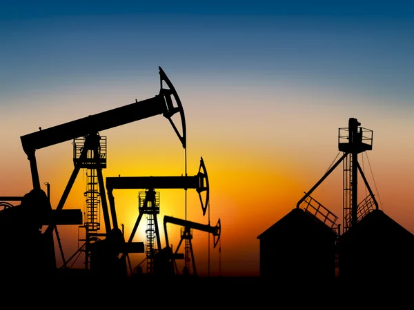 Oil field at sunset near the storage tank — Stock Photo, Image