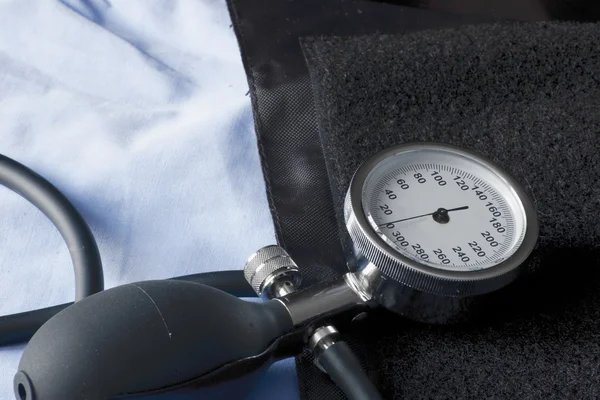 TLAKOMĔR označující nízký krevní tlak uveden na manžetu, připravené k použití — Stock fotografie