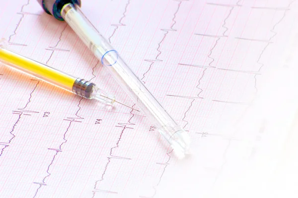 Electrocardiogram with syringe and bottle — Stock Photo, Image