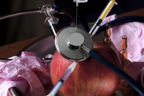 Apple surrounded by medical equipment — Stock Photo, Image