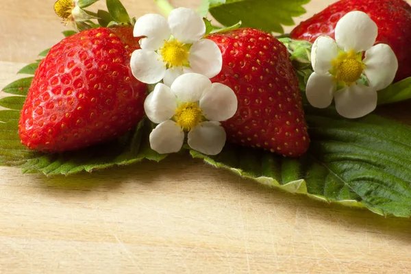 Grouped strawberries on green leaves — Stock Photo, Image
