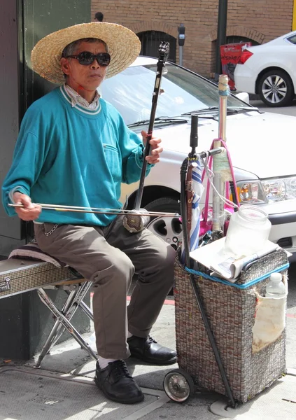 Старый китаец играет на инструменте в китайском квартале Сан-Франциско, март 2013 — стоковое фото