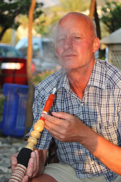 Homem fumando um cachimbo de água narguilé — Fotografia de Stock